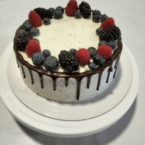 Tarta de Bizcocho chocolate con crema de nata, diseño de frutas y glaceado